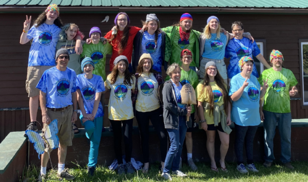The Kent UU Youth for Justice group and their advisors wearing matching t-shirts pose with a shovel