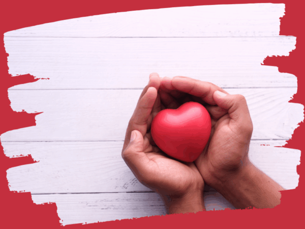 A round red heart held tenderly by a pair of hands